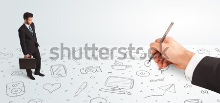 Little businessman looking at hand drawn icons and symbols Stock photo © ra2studio