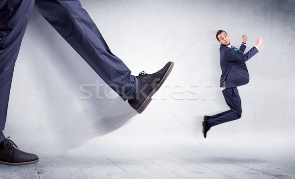 Stock photo: Big leg kicking small man
