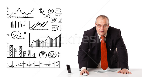 Businessman sitting at desk with diagrams and graphs Stock photo © ra2studio