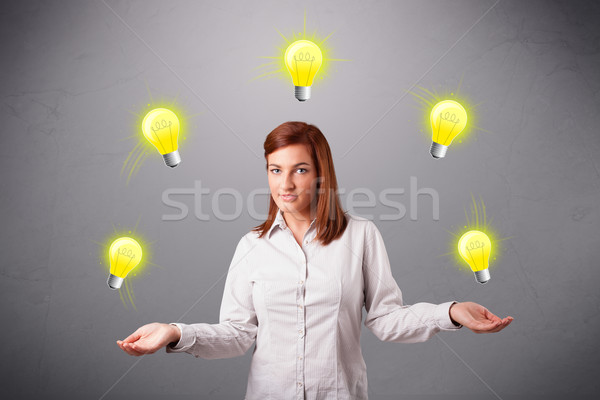 Stock photo: young lady standing and juggling with light bulbs