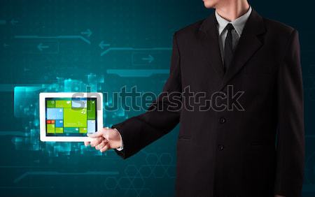 Young businessman holding a tablet with modern software operational system Stock photo © ra2studio