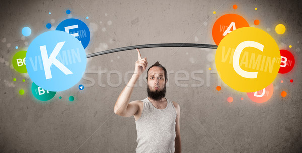 skinny guy lifting colorful vitamin weights Stock photo © ra2studio
