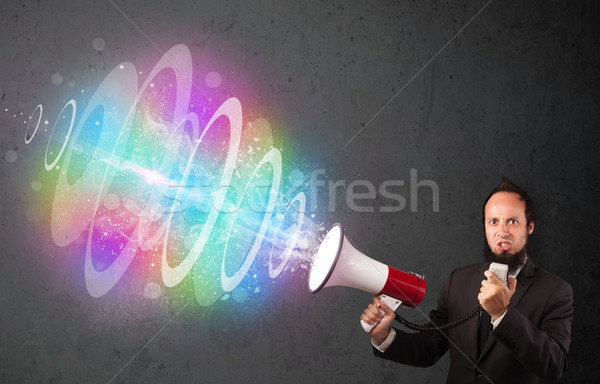 Man yells into a loudspeaker and colorful energy beam comes out Stock photo © ra2studio