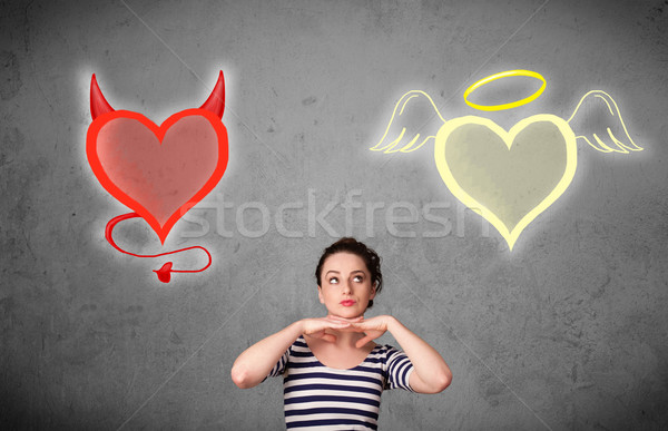 Woman standing between the angel and devil hearts Stock photo © ra2studio