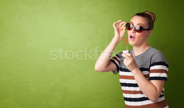 Beautiful woman blowing soap bubble on copyspace background Stock photo © ra2studio