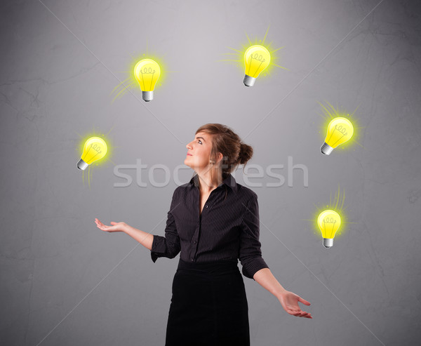 young lady standing and juggling with light bulbs Stock photo © ra2studio