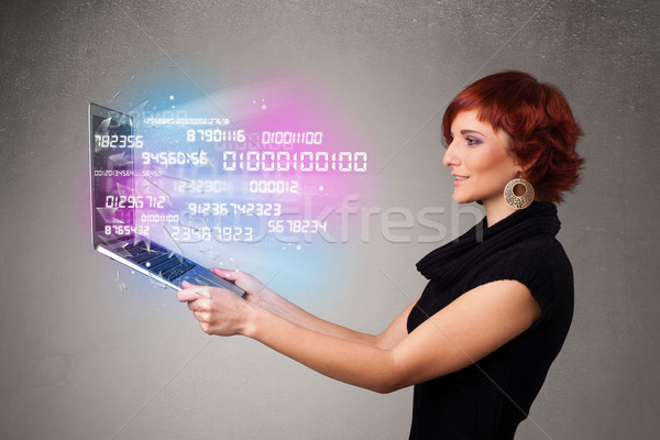 Casual woman holding laptop with exploding data and numers Stock photo © ra2studio