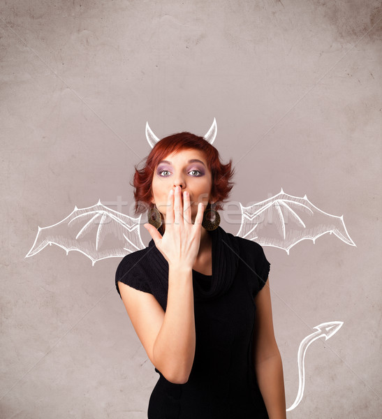 Stock photo: Young girl with devil horns and wings drawing