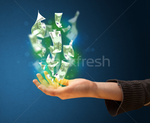 Stock photo: Glowing money in the hand of a woman