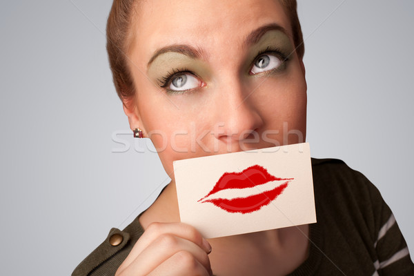Stock photo: Happy pretty woman holding card with kiss lipstick mark