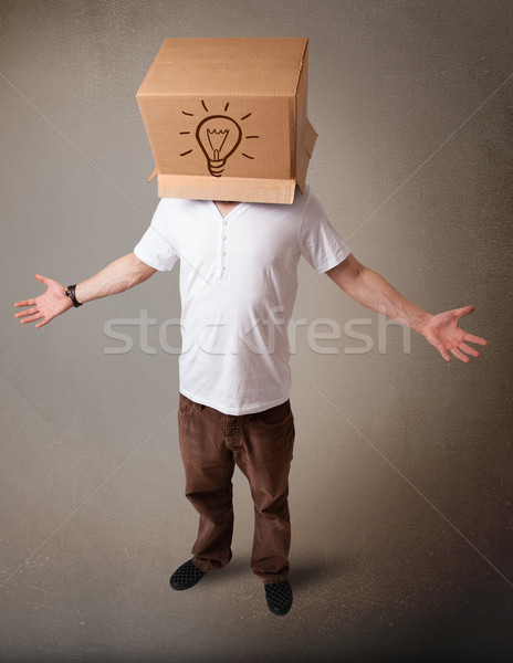 Young man gesturing with a cardboard box on his head with light  Stock photo © ra2studio