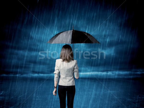 Business woman standing in rain with an umbrella Stock photo © ra2studio