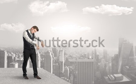 Businessman standing on the edge of rooftop Stock photo © ra2studio