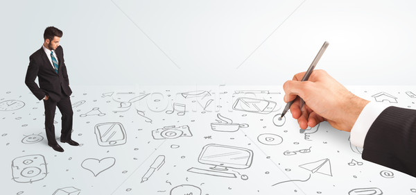 Little businessman looking at hand drawn icons and symbols Stock photo © ra2studio