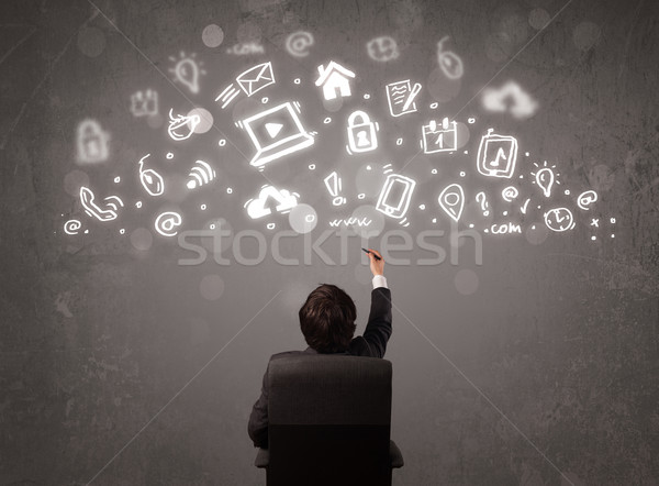 Business man looking at modern icons and symbols Stock photo © ra2studio