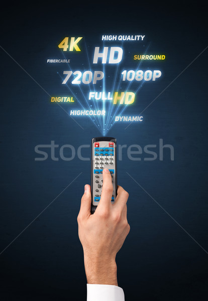 Hand with remote control and multimedia properties Stock photo © ra2studio