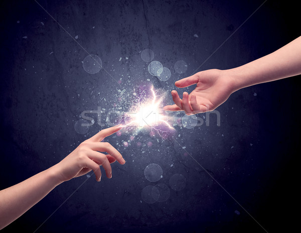 Hands reaching to light a spark Stock photo © ra2studio