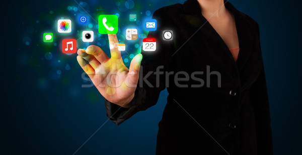 Young businesswoman pressing colorful mobile app icons with boke Stock photo © ra2studio