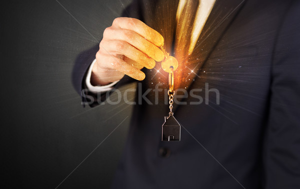 Man in suit hand over keys Stock photo © ra2studio