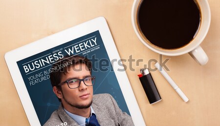 Workplace with tablet pc showing magazine cover and a cup of coffee on a wooden work table closeup Stock photo © ra2studio