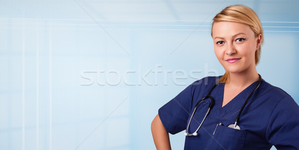 Pretty young nurse in hospital listening to empty copy space with sthetoscope Stock photo © ra2studio