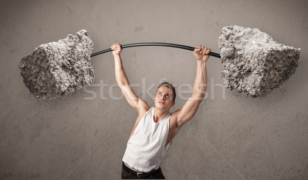 Stock photo: muscular man lifting large rock stone weights