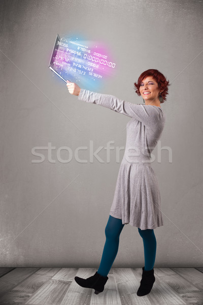 Casual woman holding laptop with exploding data and numers Stock photo © ra2studio