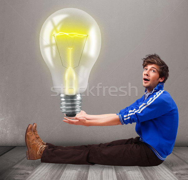 Attractive man holding realistic 3d light bulb Stock photo © ra2studio