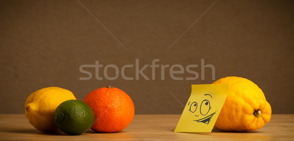 Lemon with post-it note looking curiously at citrus fruits Stock photo © ra2studio