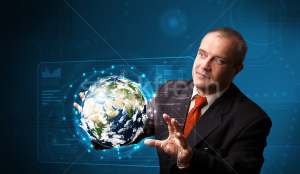 Businessman touching high-tech 3d earth panel Stock photo © ra2studio