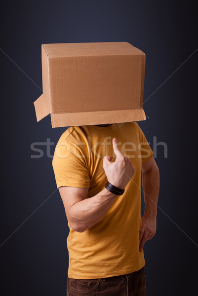 Young man gesturing with a cardboard box on his head Stock photo © ra2studio