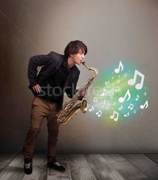 Foto stock: Jóvenes · músico · jugando · saxófono · notas · musicales · atractivo