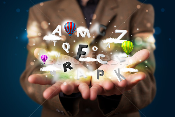 Young businessman presenting magical clouds with letters and bal Stock photo © ra2studio