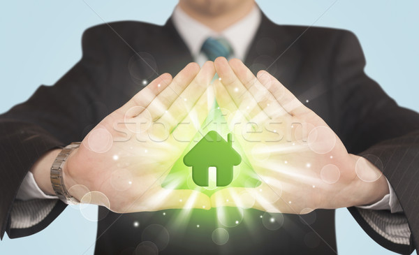 Stock photo: Hands creating a form with green house