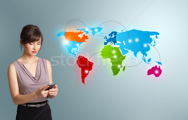 Young woman holding a phone and presenting colorful world map Stock photo © ra2studio