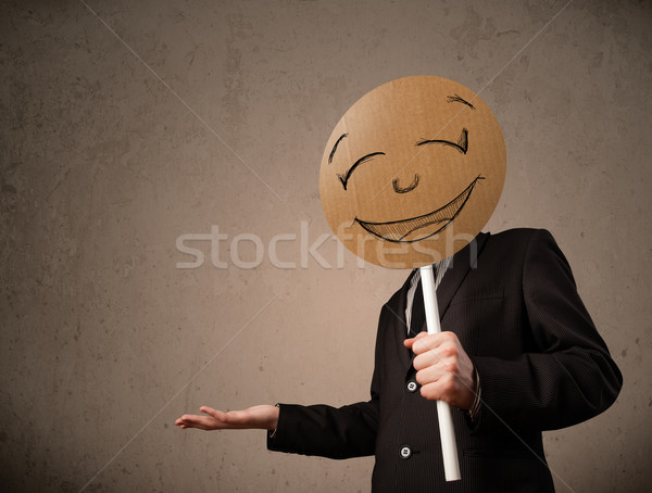 Businessman holding a smiley face board Stock photo © ra2studio
