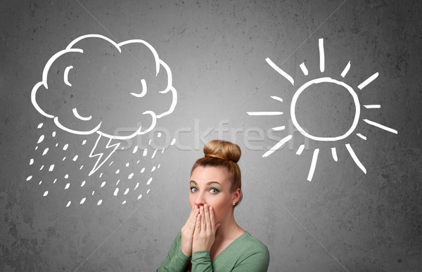 Stock photo: Woman standing between a sun and a rain drawing