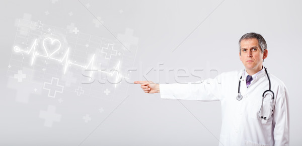 Doctor examinates heartbeat with abstract heart Stock photo © ra2studio