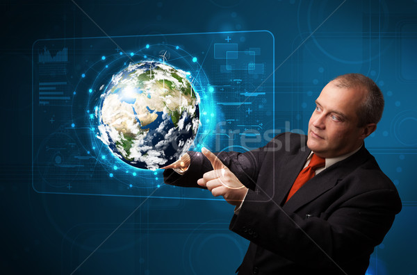 Businessman touching high-tech 3d earth panel Stock photo © ra2studio