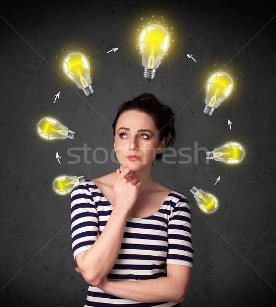Young woman thinking with lightbulb circulation around her head Stock photo © ra2studio