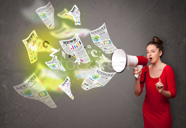 Girl yelling into loudspeaker and newspapers fly out Stock photo © ra2studio