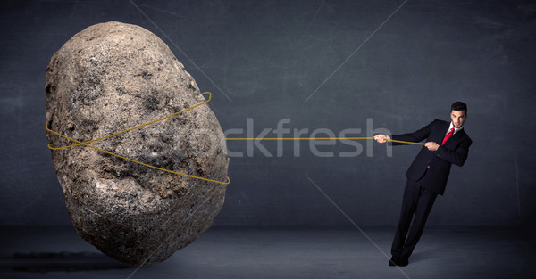 Businessman pulling huge rock with a rope  Stock photo © ra2studio