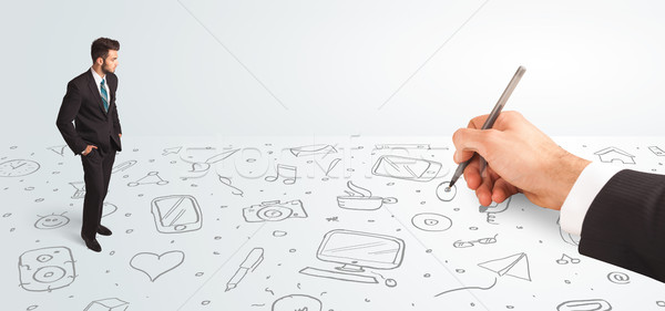 Little businessman looking at hand drawn icons and symbols Stock photo © ra2studio
