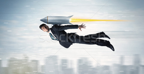 Superhero business man flying with jet pack rocket above the cit Stock photo © ra2studio