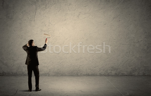 Salesman with roller standing at empty wall Stock photo © ra2studio