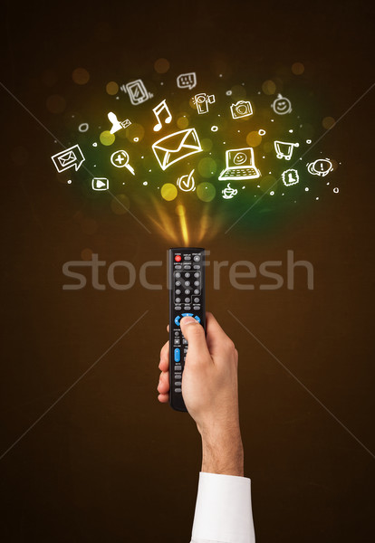 Hand afstandsbediening social media iconen uit Stockfoto © ra2studio