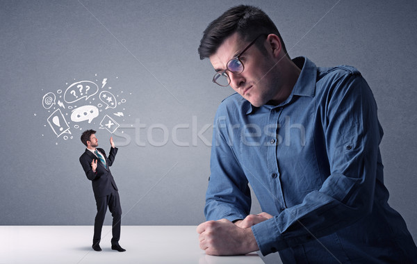 Young businessman fighting with miniature businessman Stock photo © ra2studio