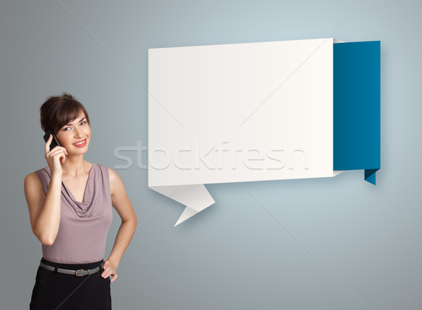 pretty young woman standing next to modern origami copy space and making phone call Stock photo © ra2studio