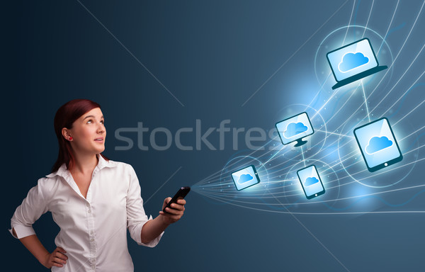 Stock photo: Pretty lady typing on smartphone with cloud computing