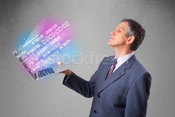 Stock photo: Businessman holding notebook with exploding data and numbers